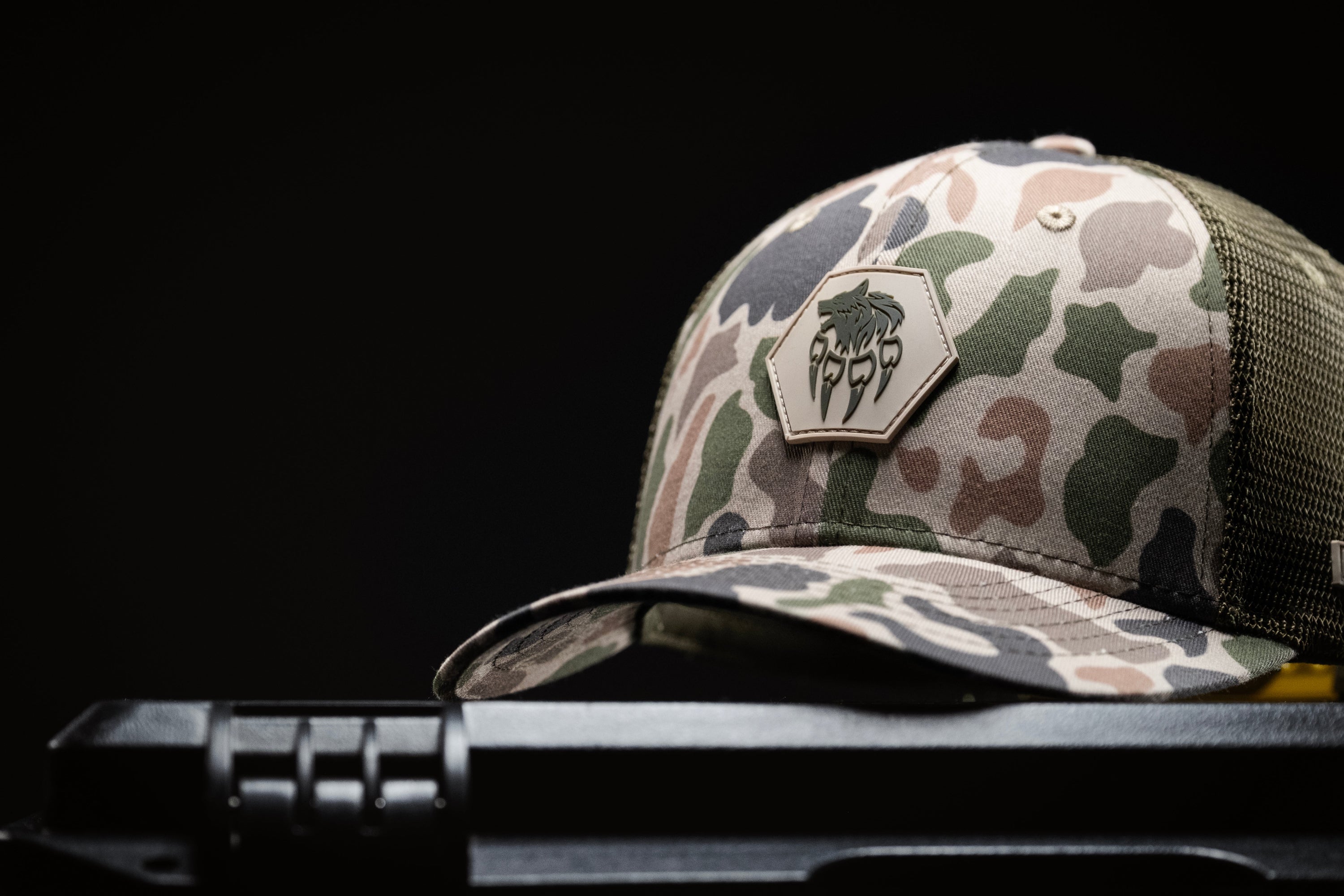 Alpha Geir camouflage Frog Skin truckers cap with AG logo on a black background